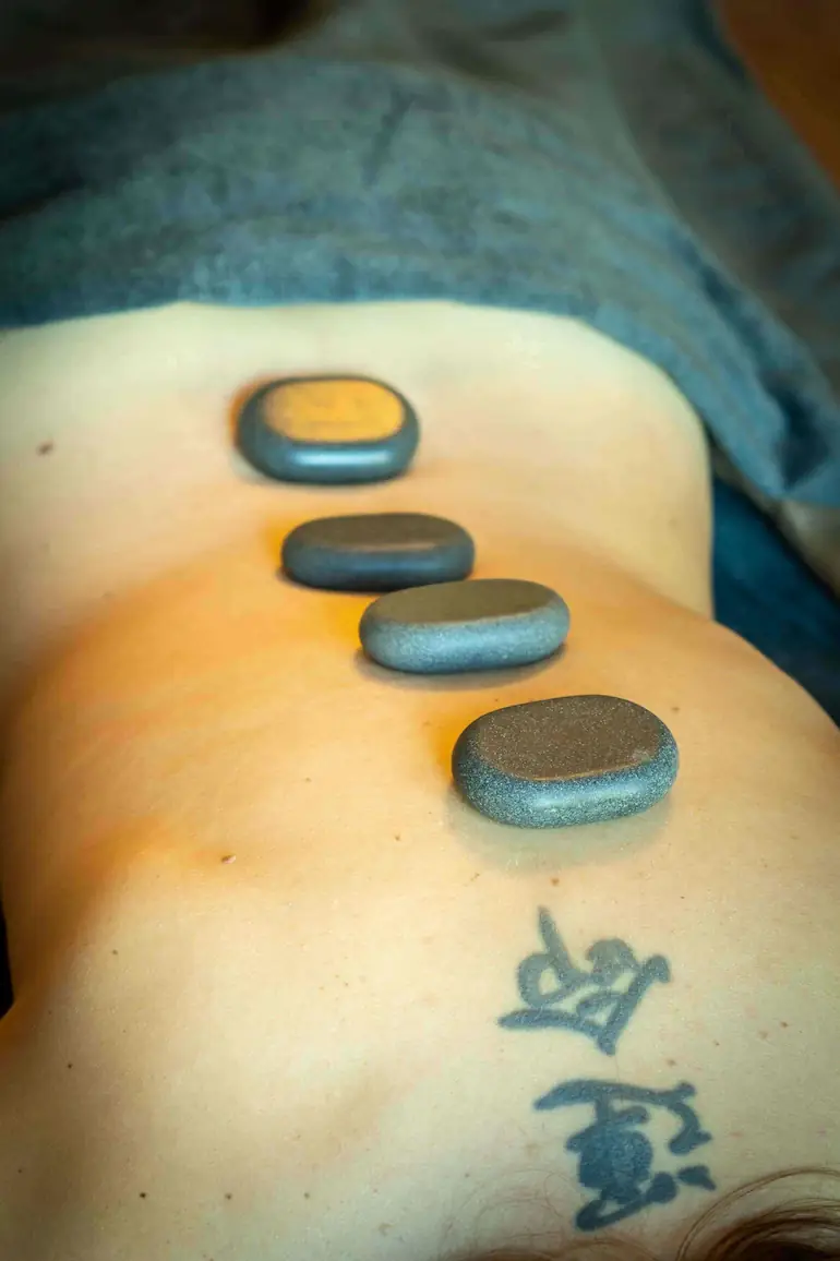 Stenen op rug van dame tijdens massage